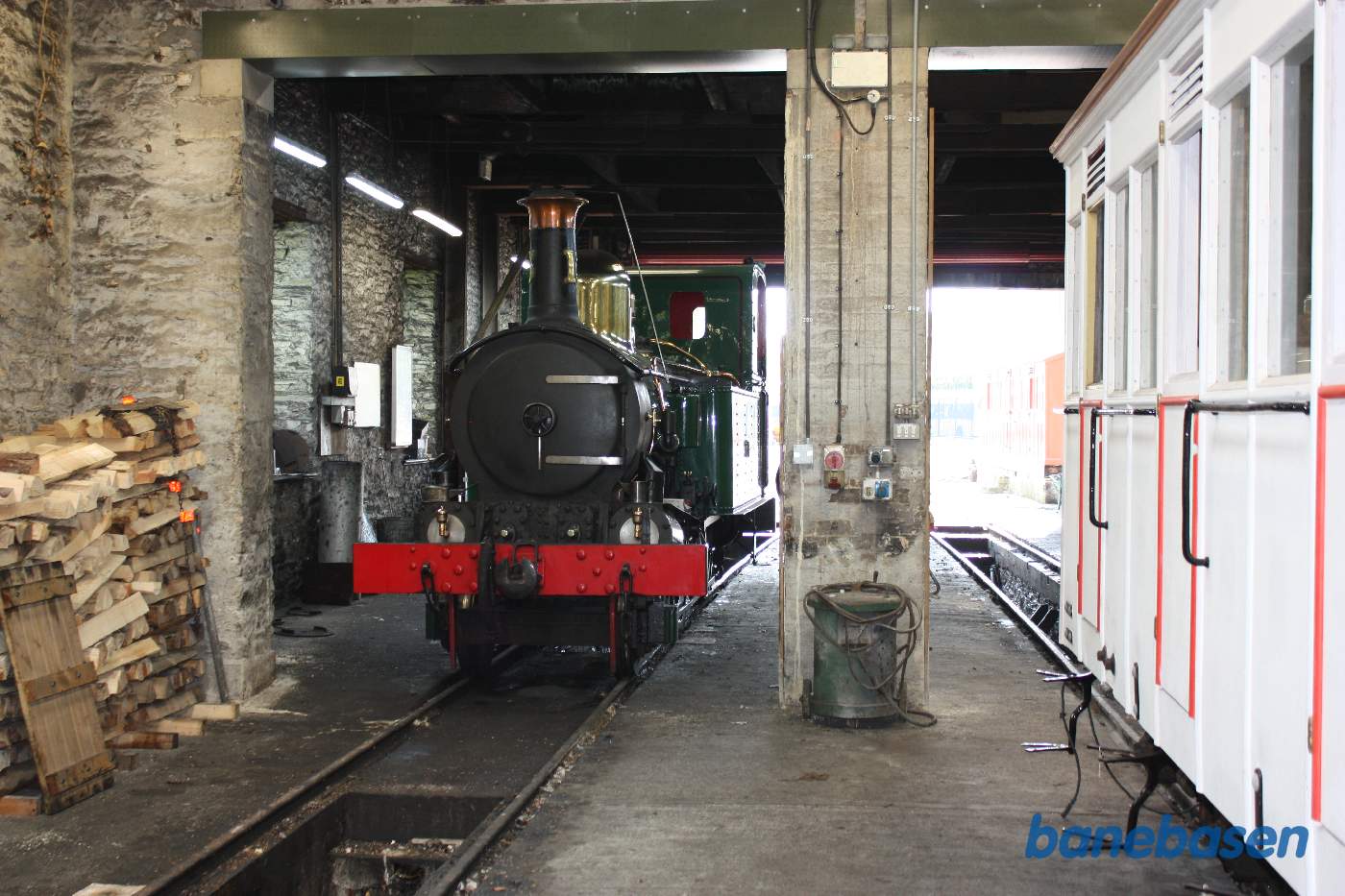 Damplokomotiv til venstre og hvid personvogn til højre