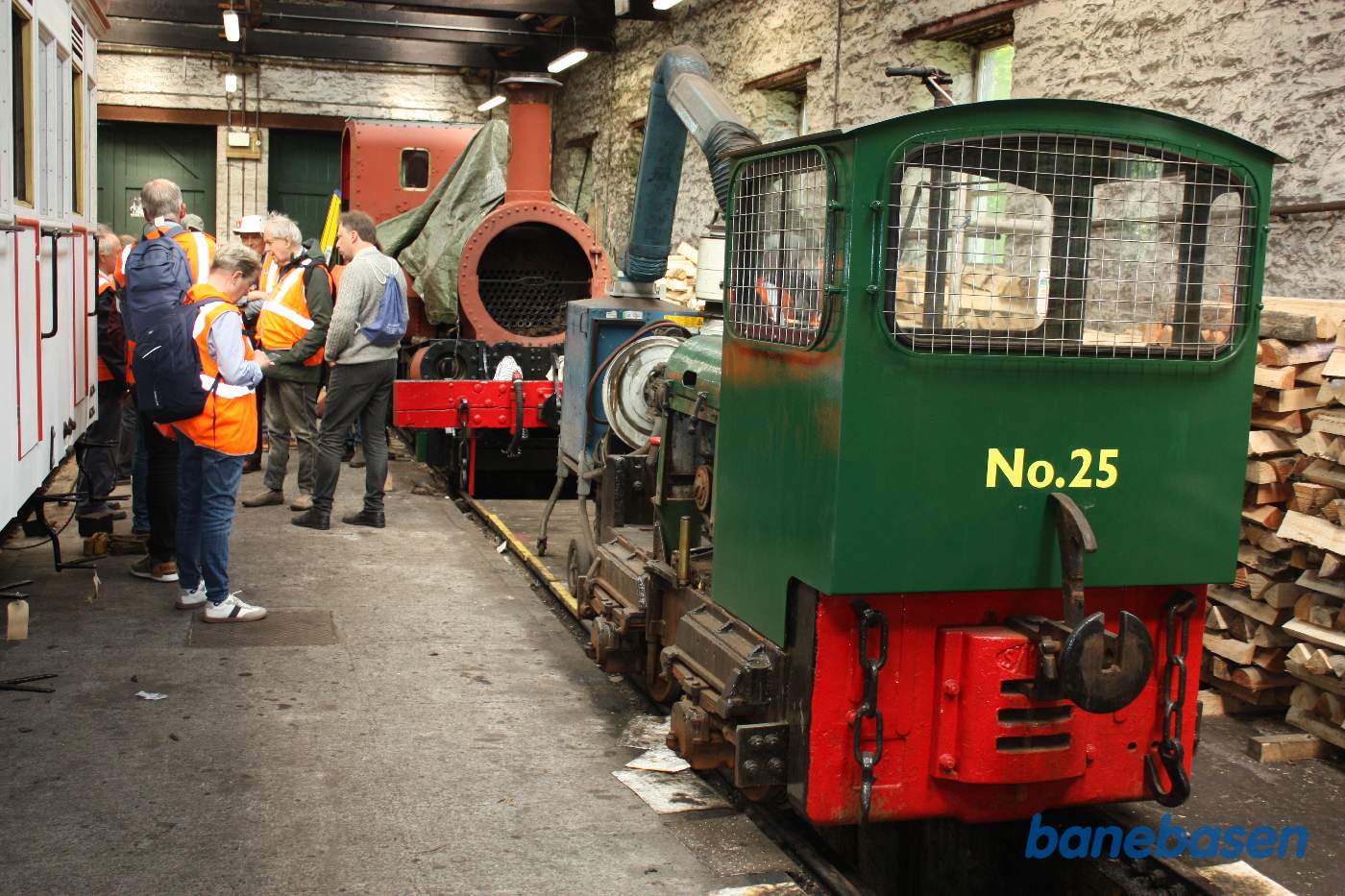 På den anden side af den hvide personvogn, et lille diesellokomotiv og bag det et damplokomotiv