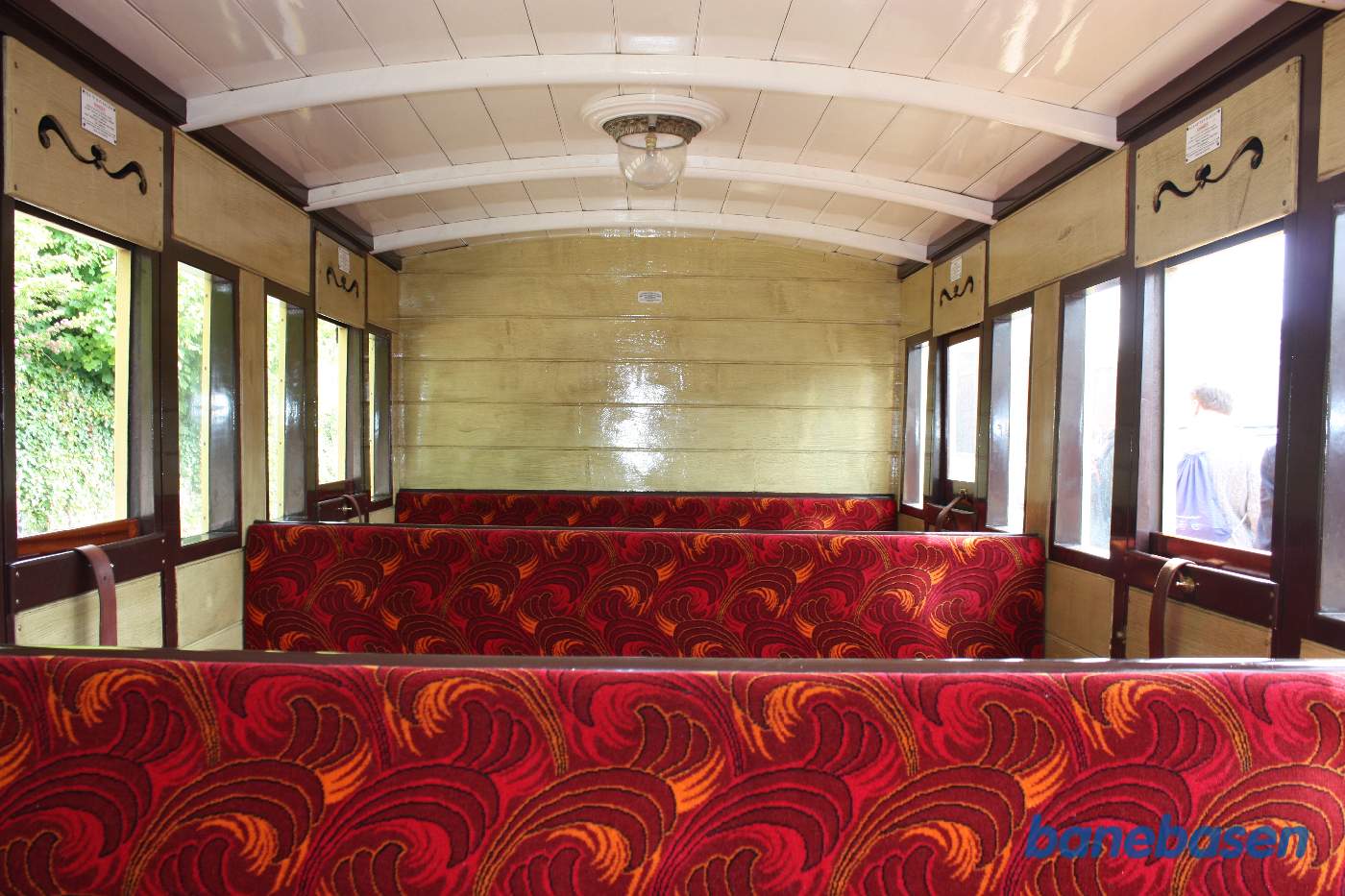 Billede af en vogn indefra, rødt polster på sæderne i storrumskupéen