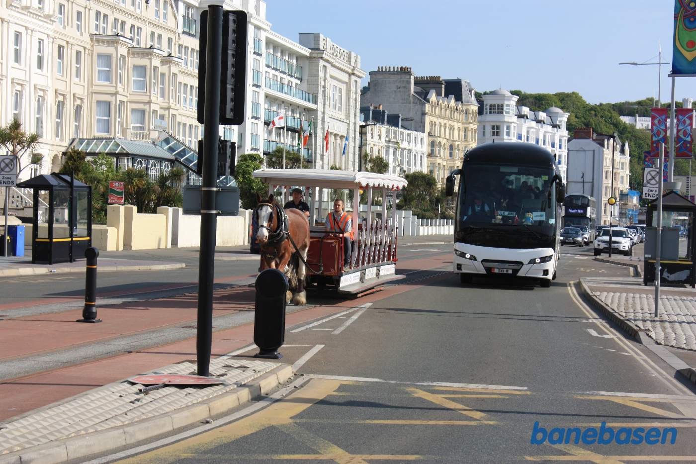 Hestesporvognen kommer kørende foran The Empress Hotel, en stor bus venter