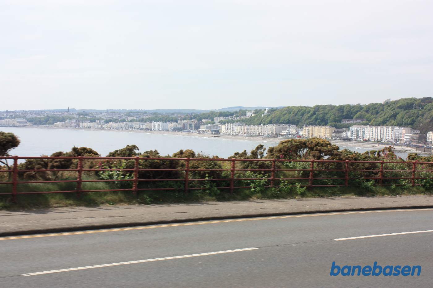 Sporvognen er på vej ud af Douglas. Det første stykke vej løber vejen og banen langs kysten