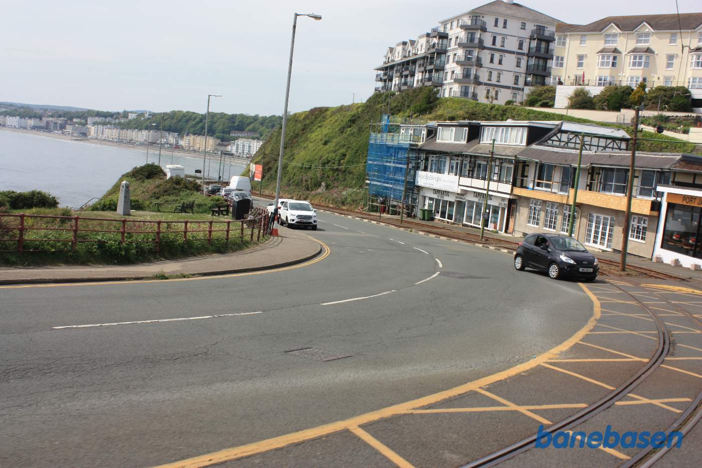 Sporvognen er på vej ud af Douglas. Det første stykke vej løber vejen og banen langs kysten