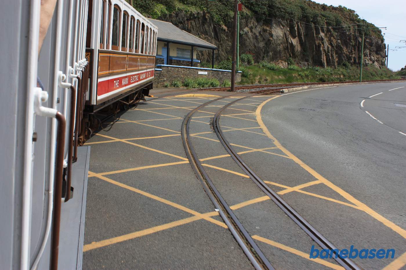 Sporvognen er på vej ud af Douglas. Det første stykke vej løber vejen og banen langs kysten