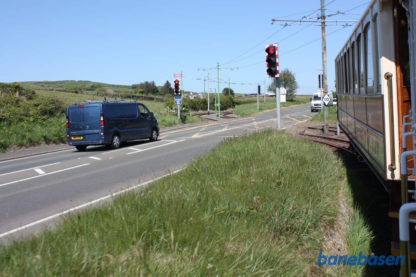 Sporvognen er på vej ud af Douglas. Det første stykke vej løber vejen og banen langs kysten, her en vejoverkørsel med lyssignaler