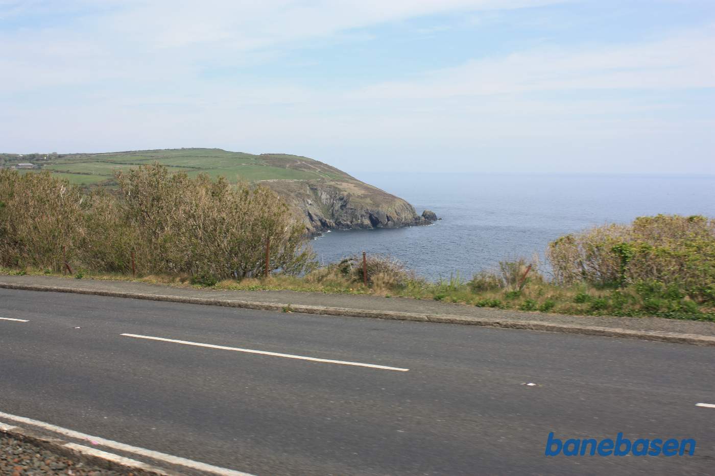 Sporvognen er på vej ud af Douglas. Det første stykke vej løber vejen og banen langs kysten