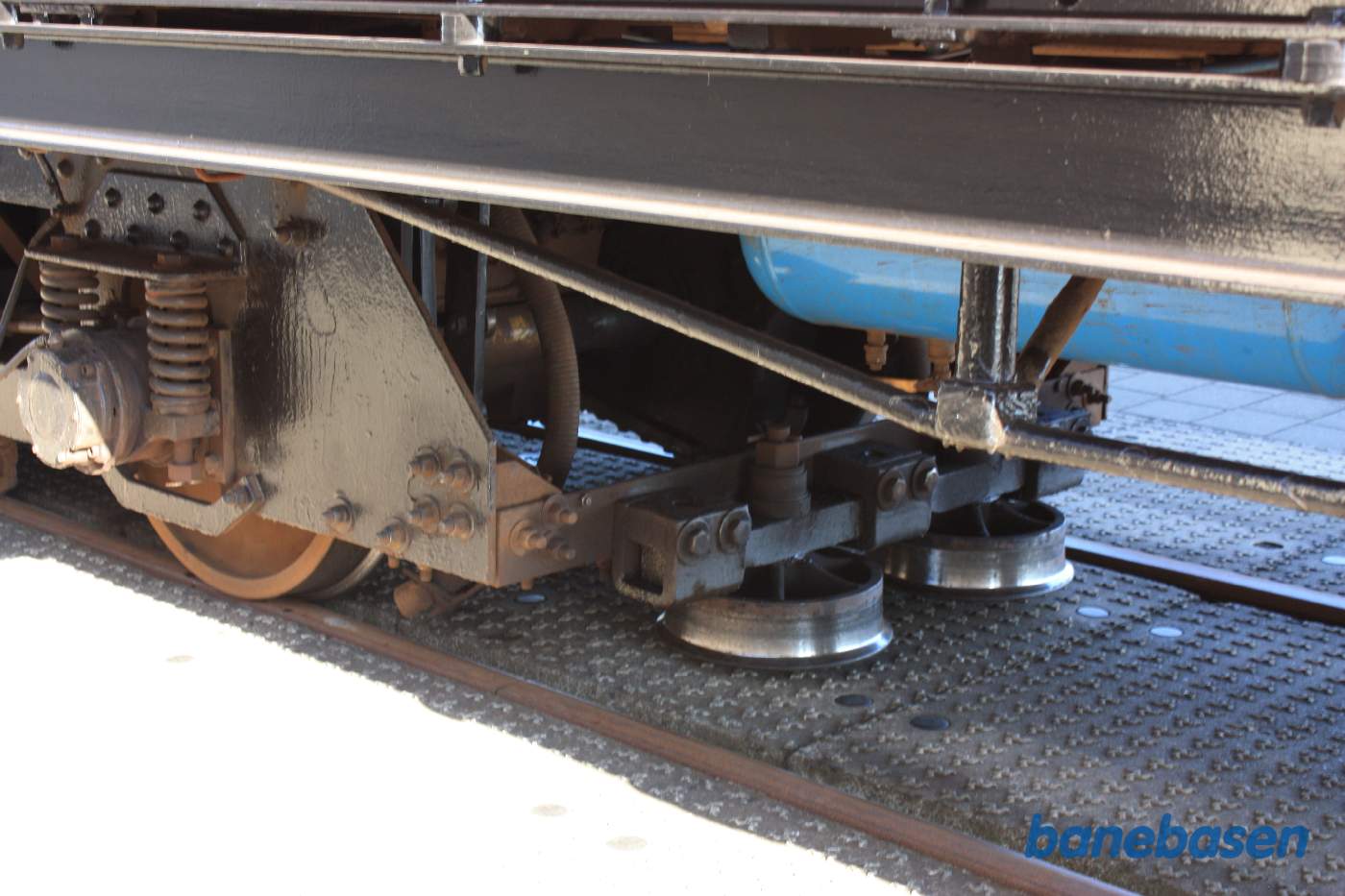 Nærbillede af rullerne der er med til at styre vognen via tandstangen midt i sporet