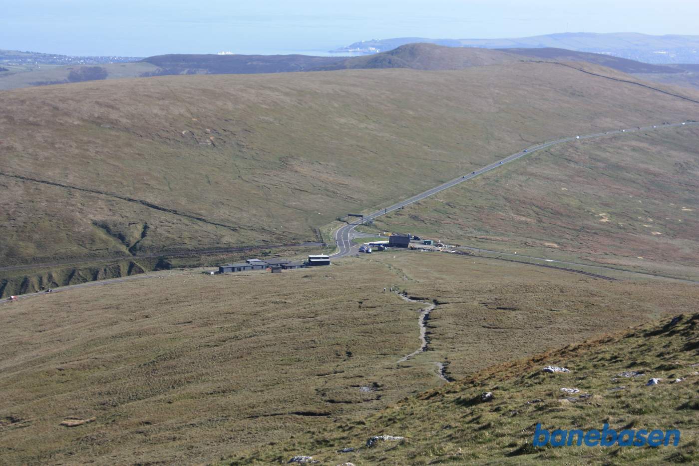 Udsigten fra Snaefell, sporvejen krydser over hovedvejen og til højre Bungalow Station, til venstre en restaurant