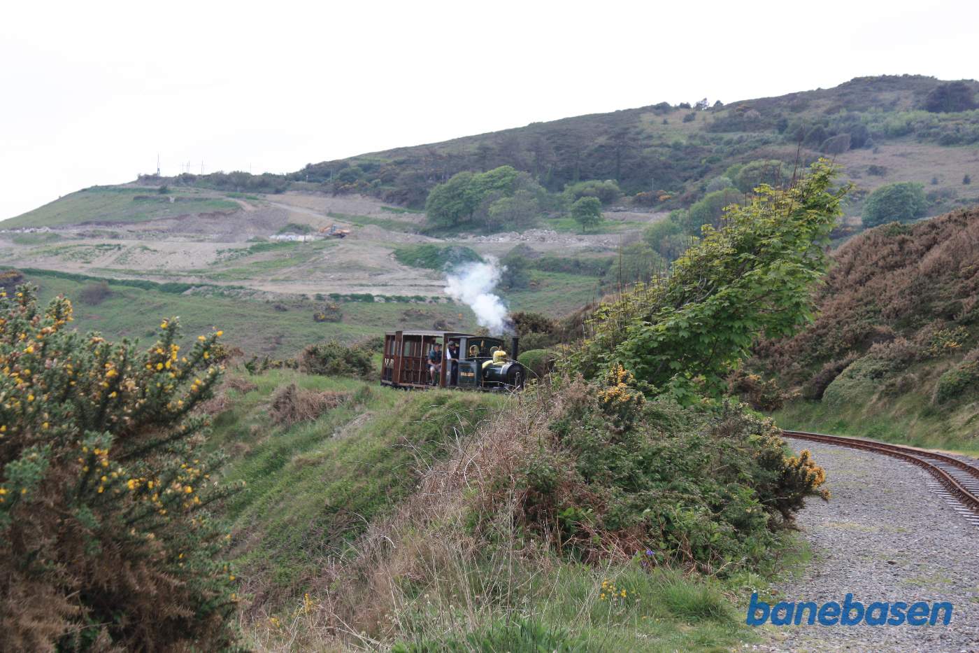 Damptog på vej langs bjergkanten ned mod havet