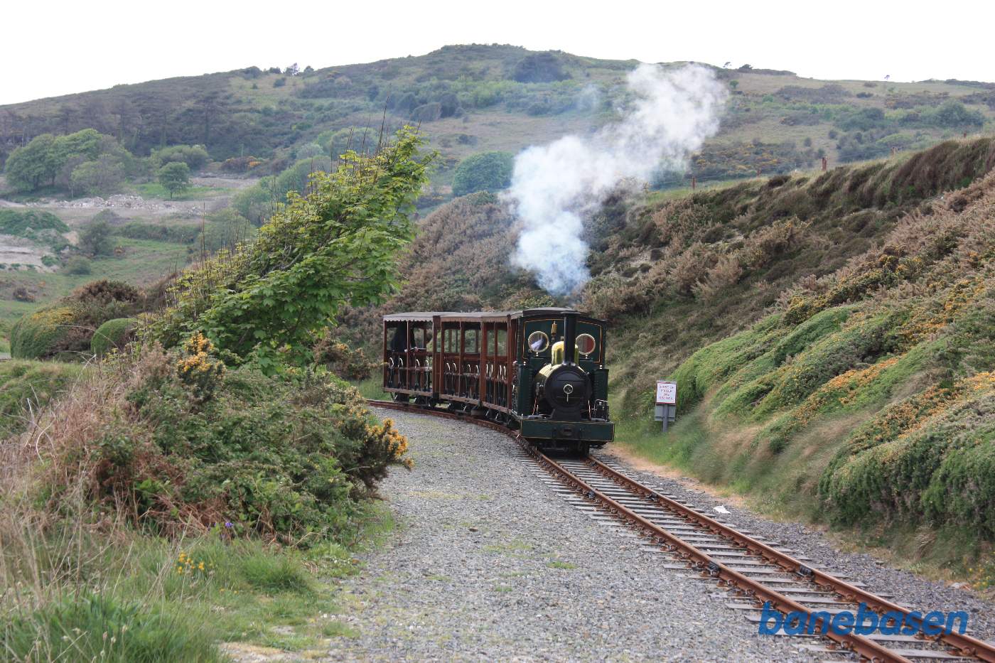 Damptog på vej langs bjergkanten ned mod havet