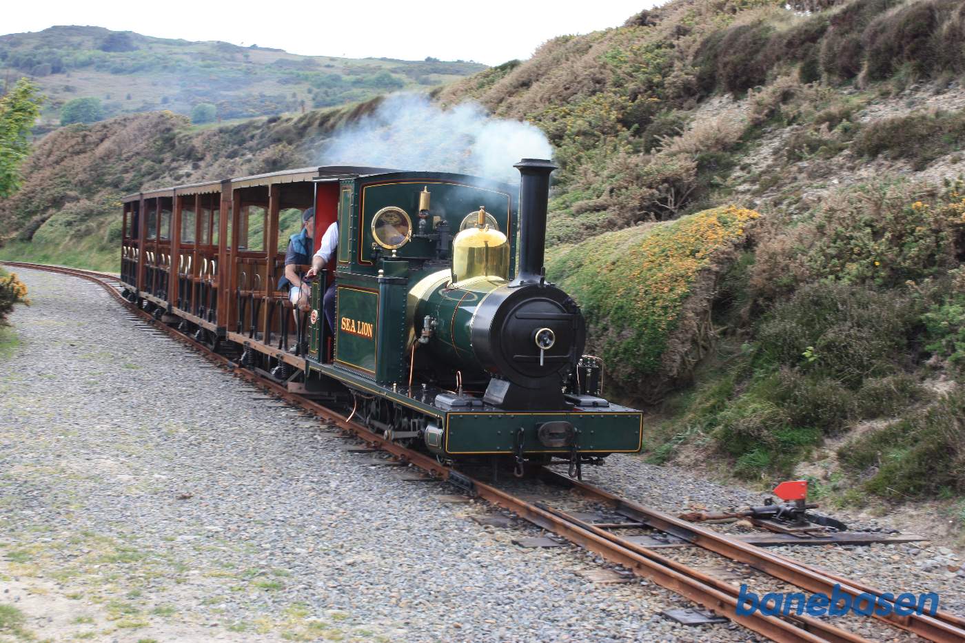 Damptog på vej langs bjergkanten ned mod havet