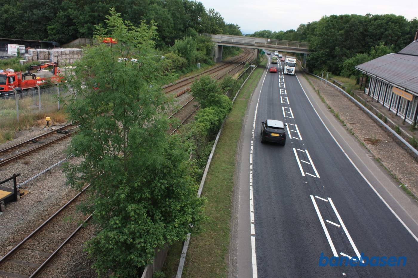 Udsigten fra gangbroen mod vest. Stationsbygningen til højre. Banen flyttet for at give plads til hovedvejen