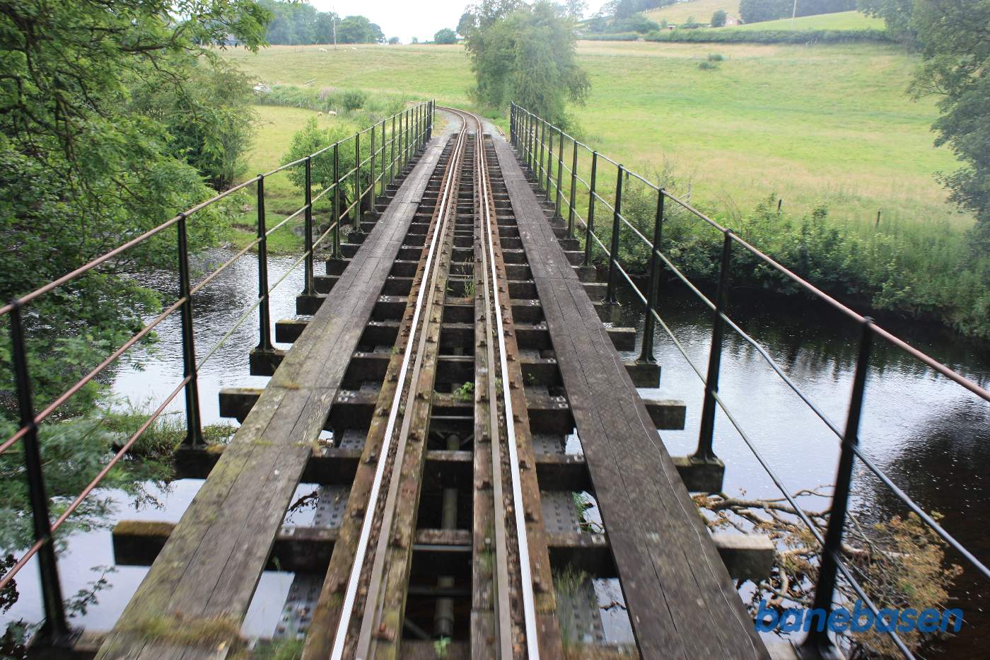 Banen krydser over floden på en bro, banen set fra bagperronen
