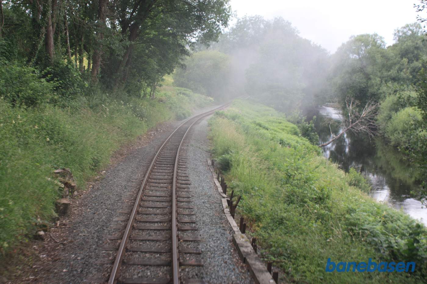 Damptoget på vej ud over markerne, banen set fra bagperronen