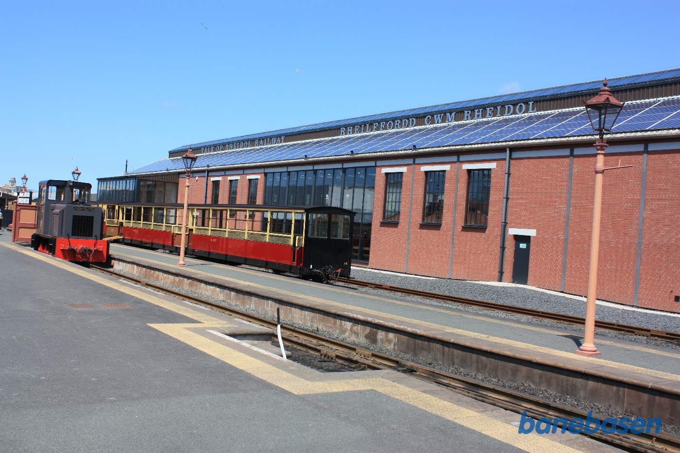 Vognene fra persontoget ved perron, museumshallen i baggrunden