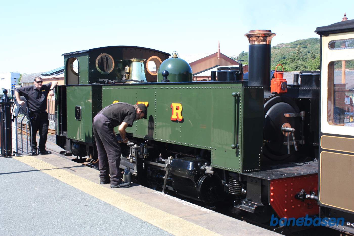Så holder damptoget ved perron og fyrbøderen tjekker smøringen