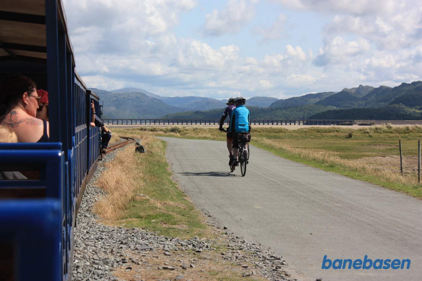Damptoget fortsætter mod endestationen. Cyklister på vejen