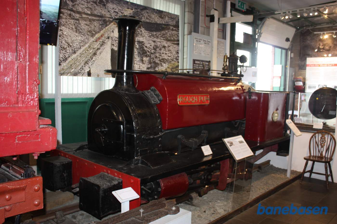 Udstilling af mange ting fra banen, her et rødt damplokomotiv med saddel vandtank