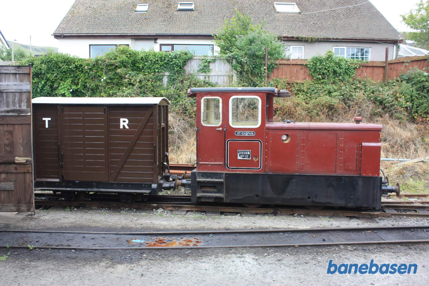 Et rødt diesellokomotiv holder inde til siden