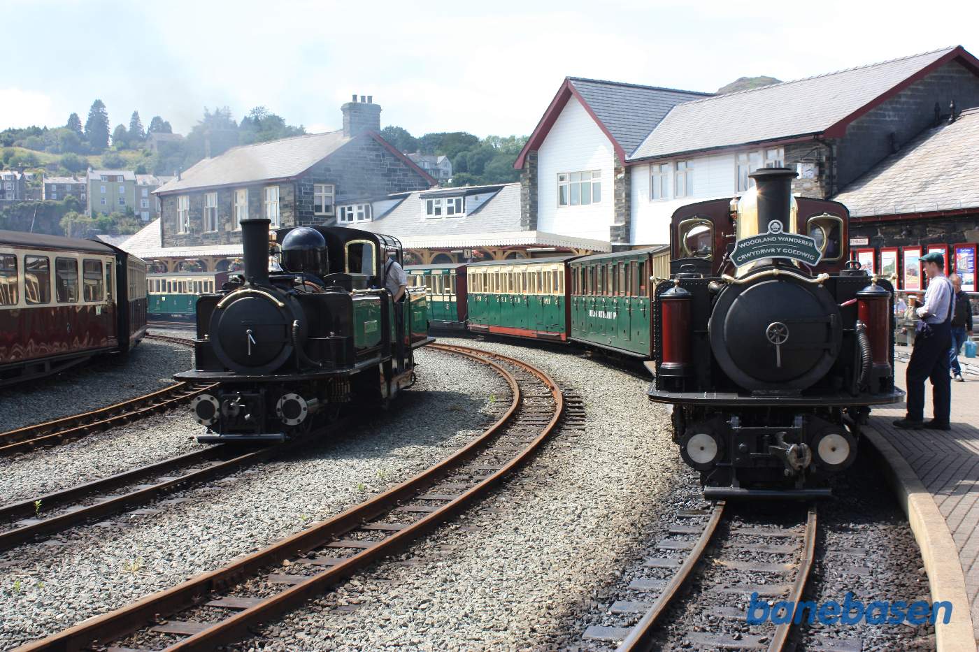 Et damptog ved perron og et lokomotiv på vej fra forsyningen