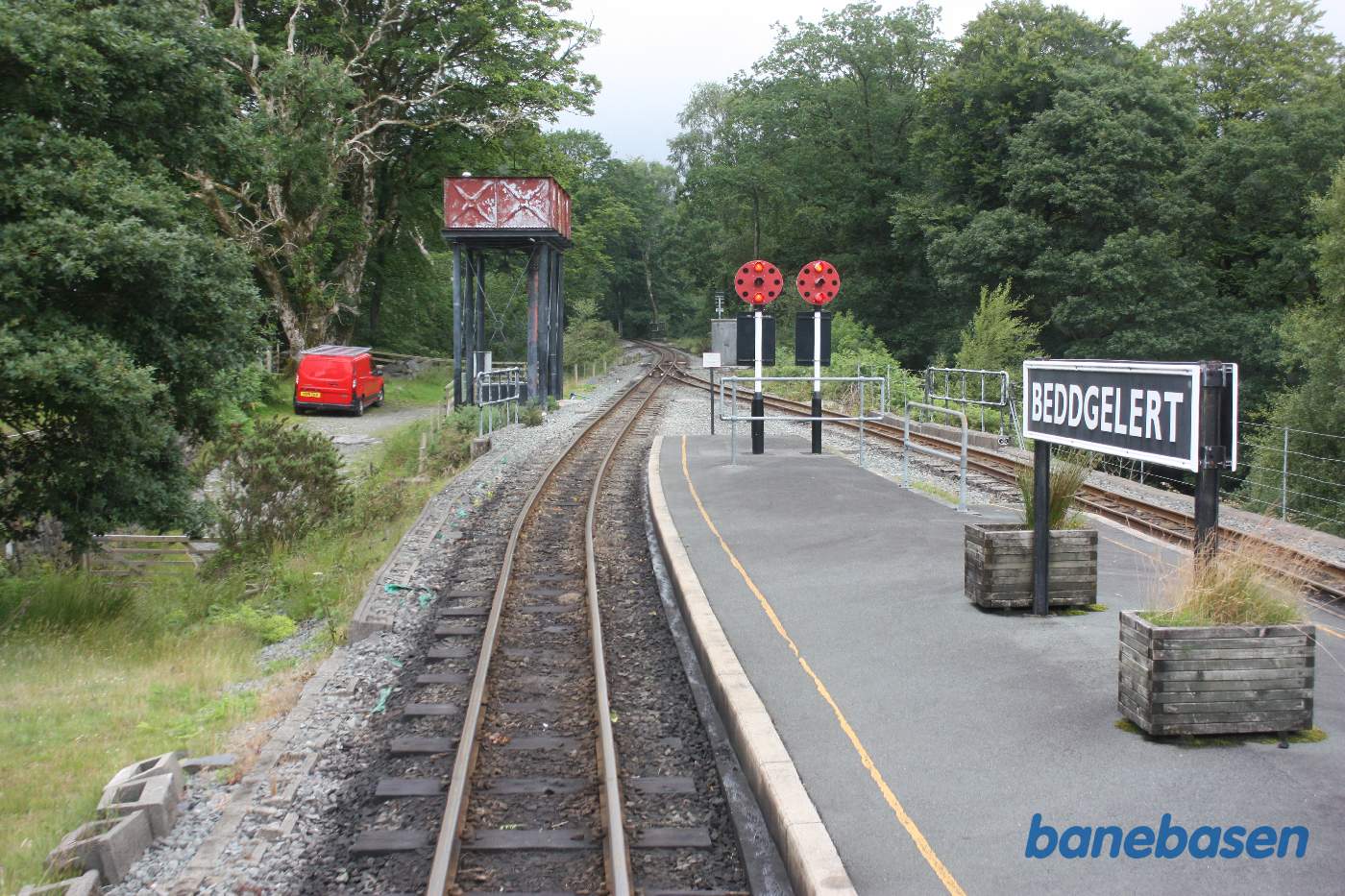 Toget på vej ind på stationen, stationsskiltet på perronen