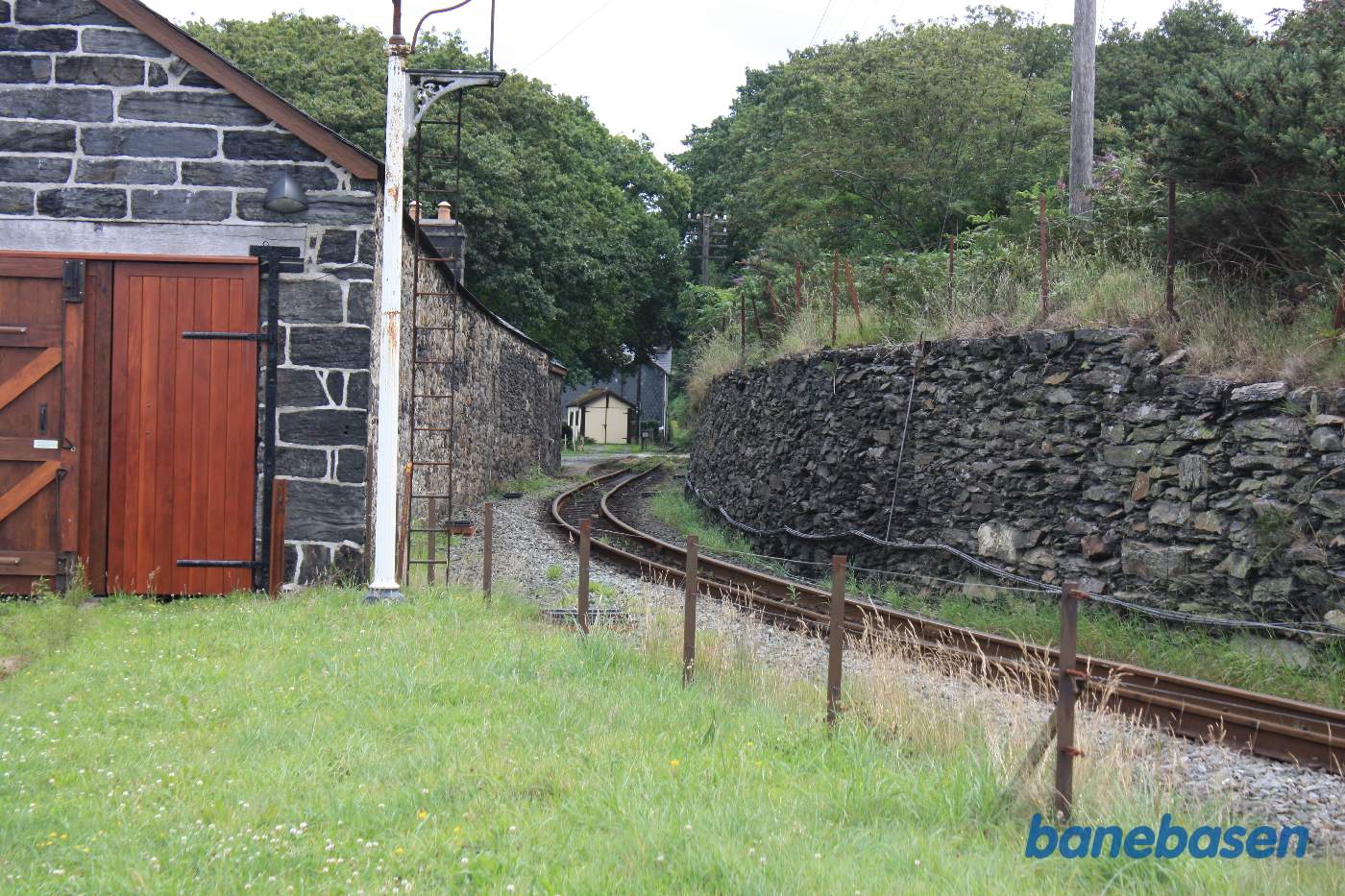 Hovedsporet løber langs stenbygningen, trinbrættet ses bag bygningen