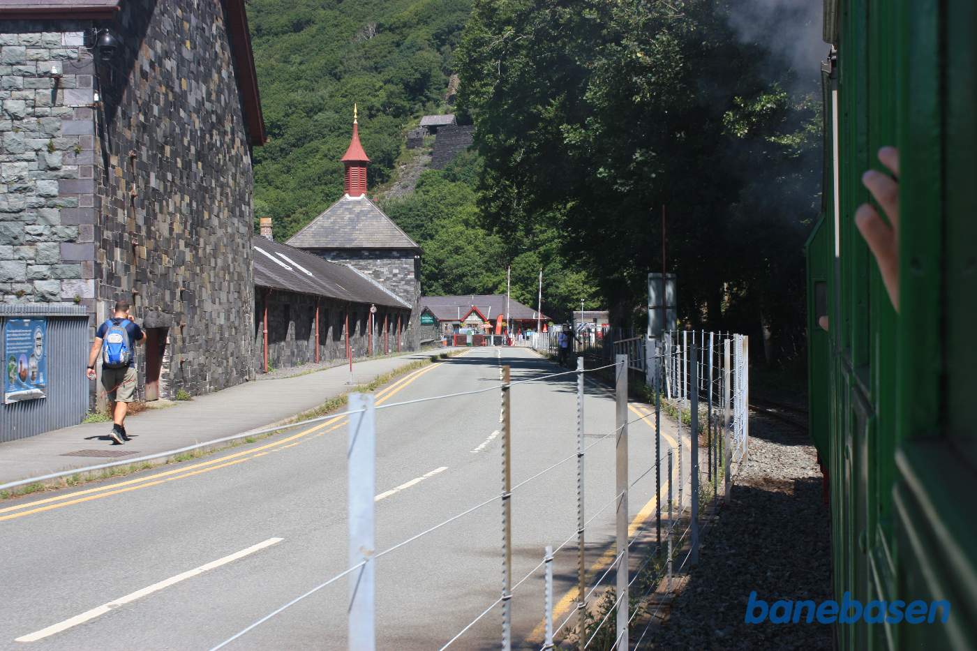 Persontoget nærmer sig Gilfach Ddu station. The National Slate Museums bygninger inde til venstre