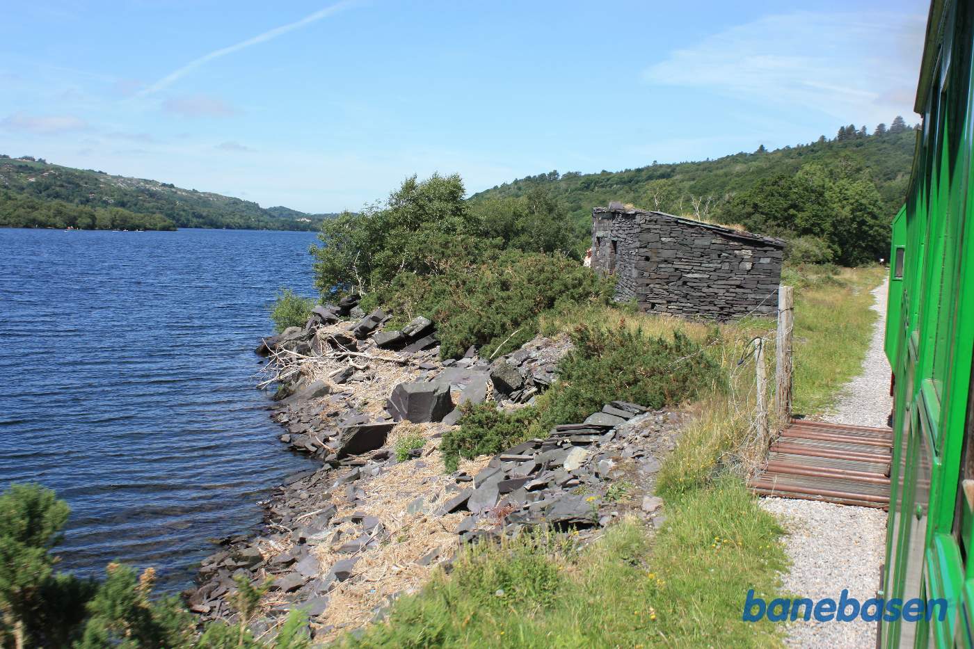 Toget passerer en lille stenbygning på venstre side