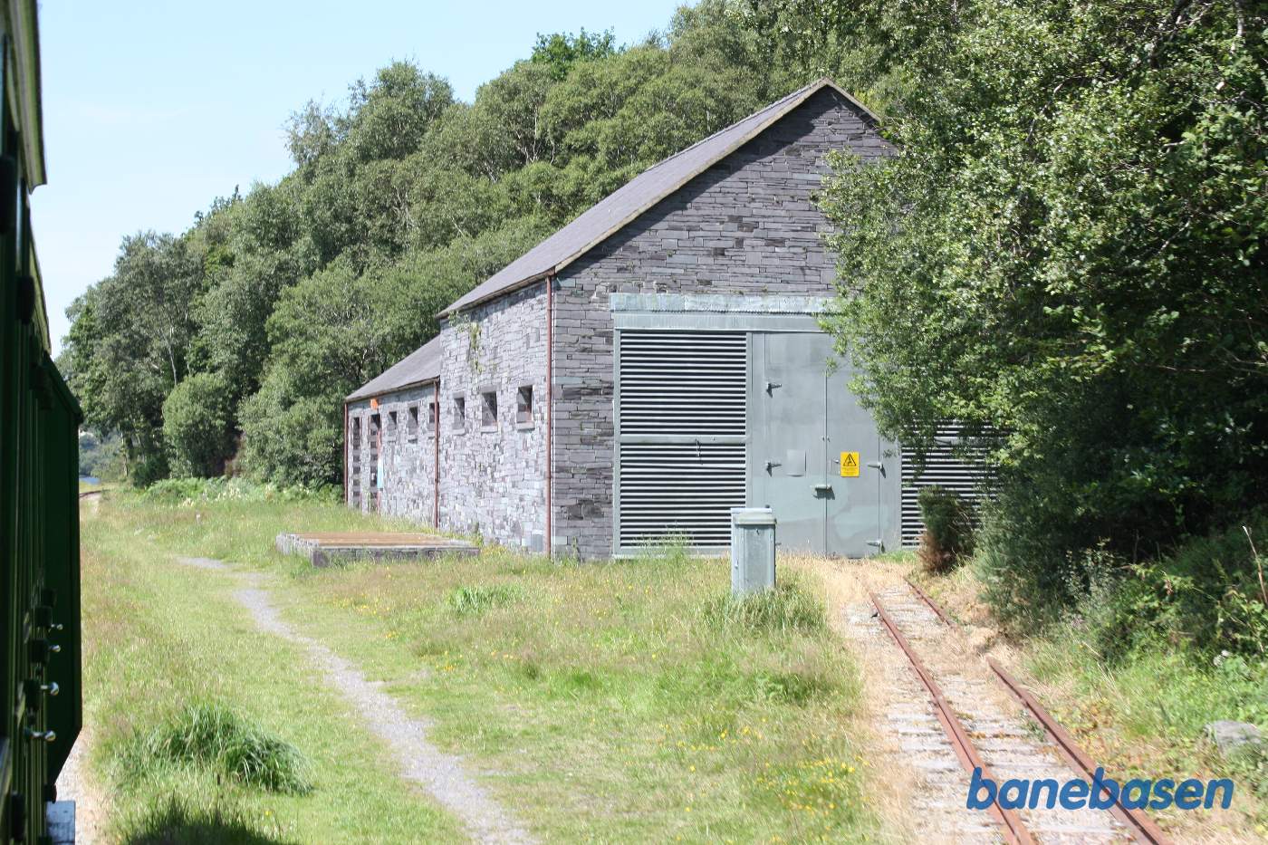 Et sidespor går ind i en stor transformator bygning