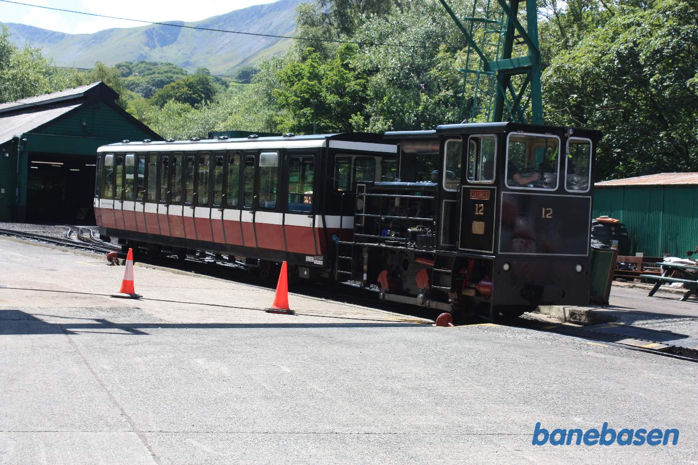 Persontog med diesellokomotiv på vej ind på stationen