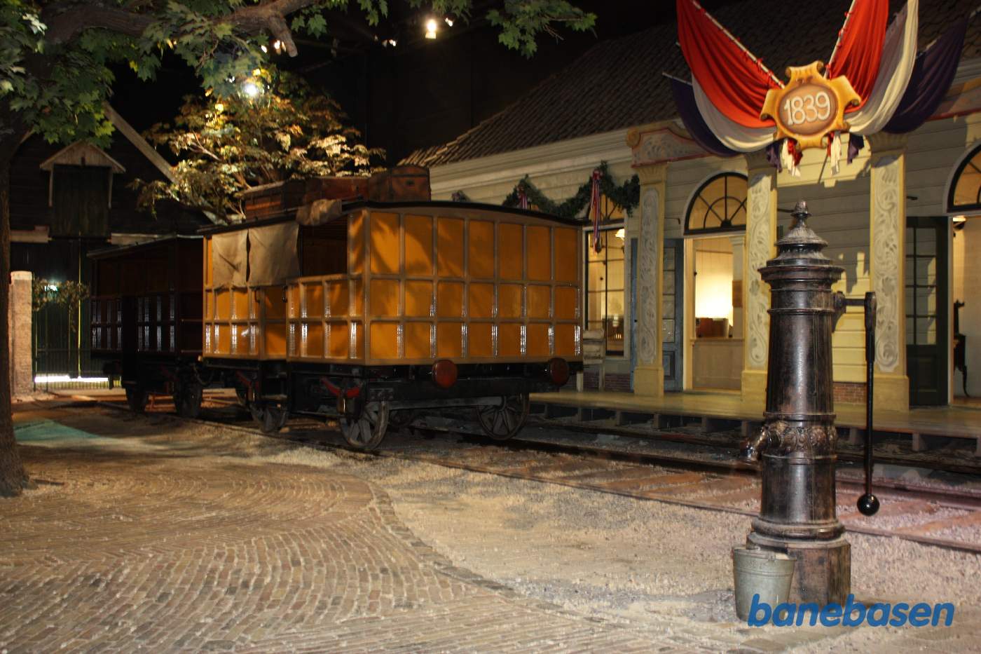 Bredsporspersonvogn ved perron inde i museumshallen