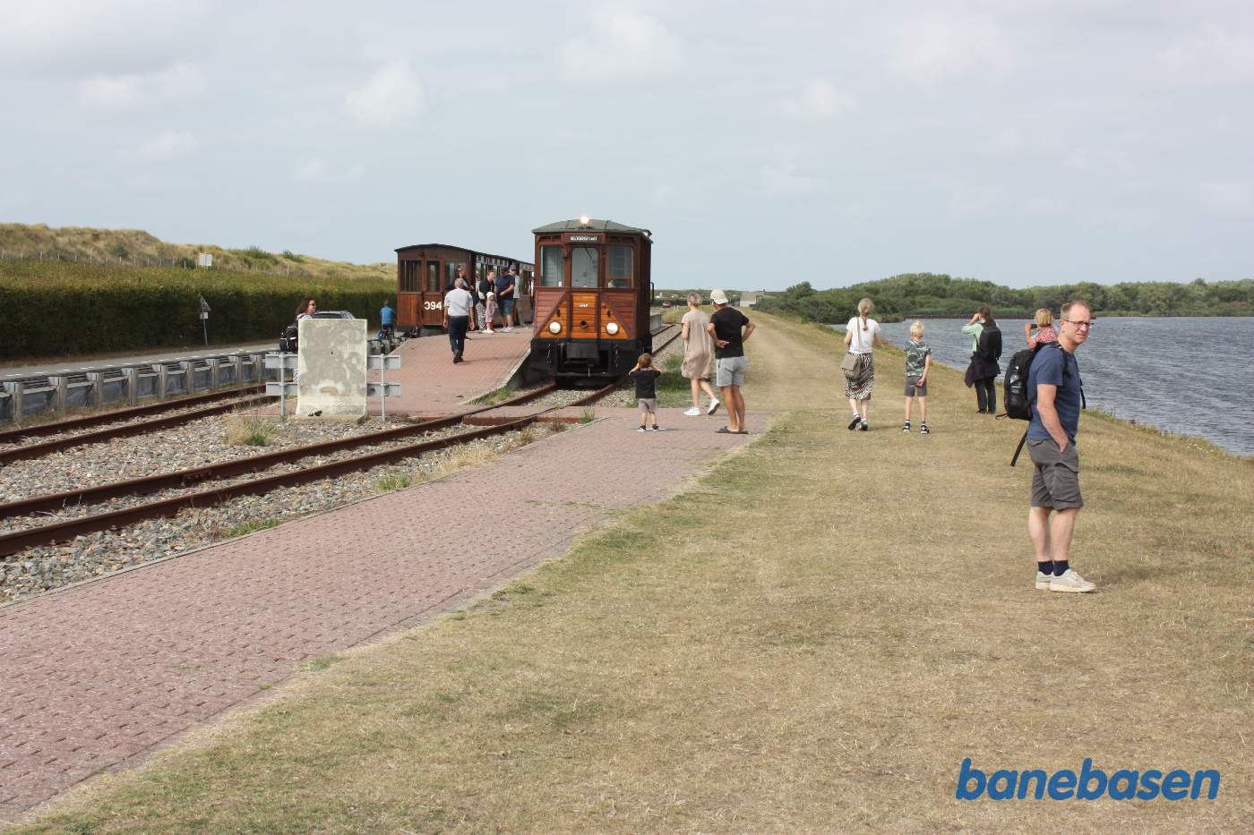 Motorvognen omløber toget i perronsporet mens de rejsende ser på