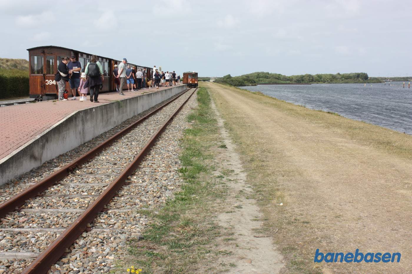 Motorvognen omløber toget i perronsporet mens de rejsende ser på