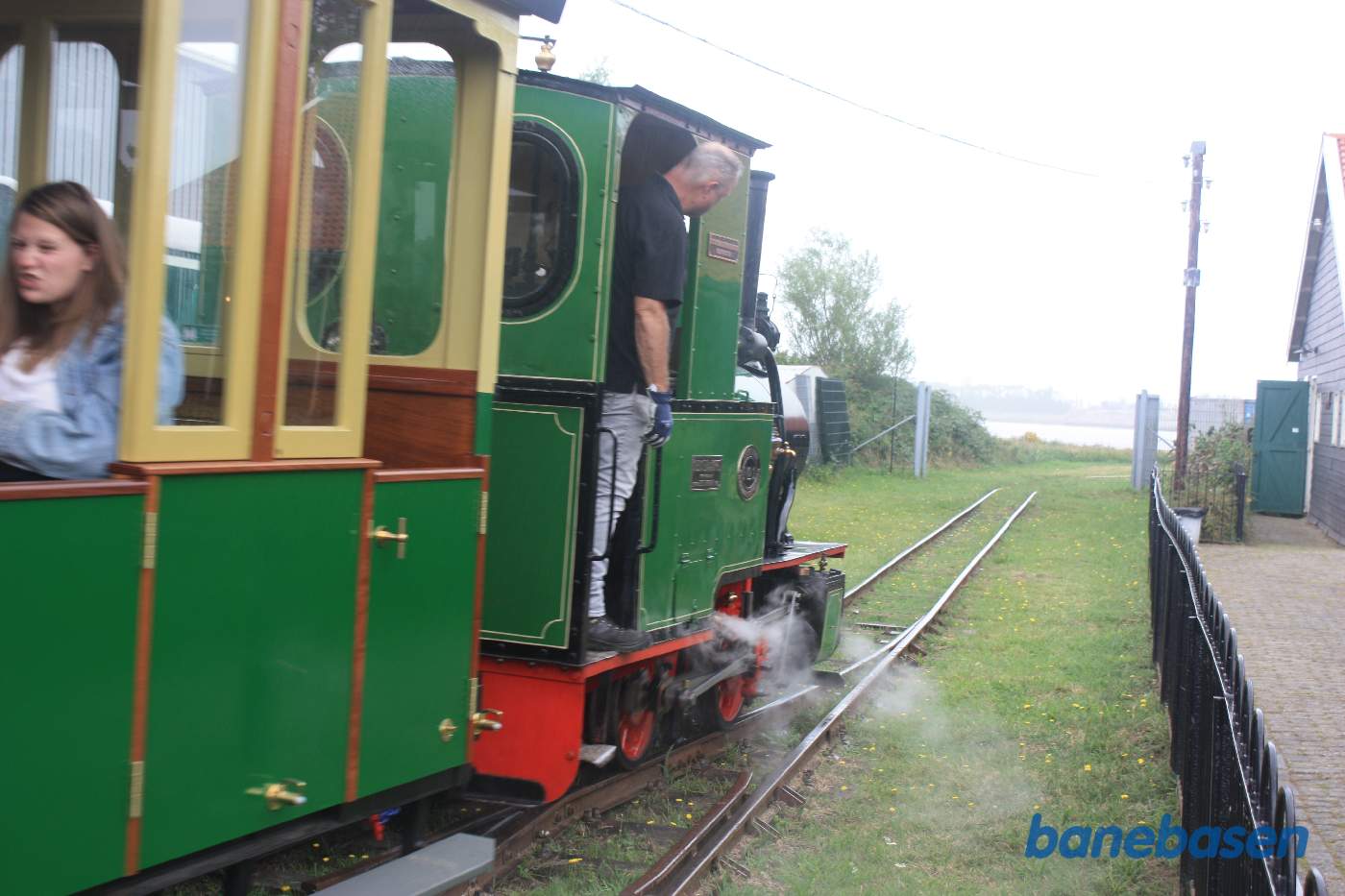 Toget damper ud af stationen. Søen i baggrunden