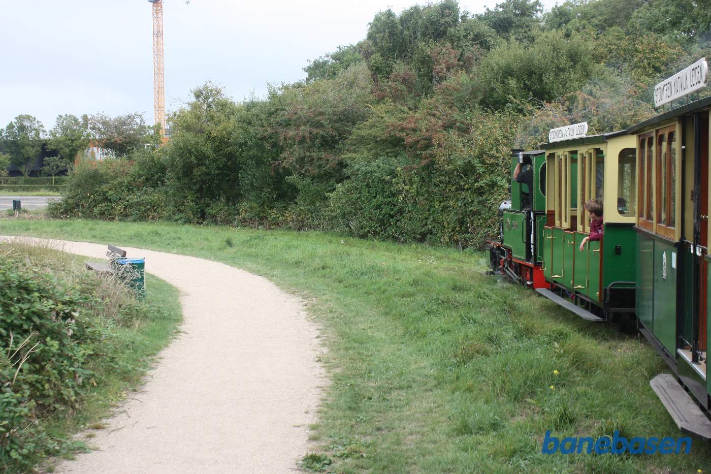 Toget kører i parken langs søen