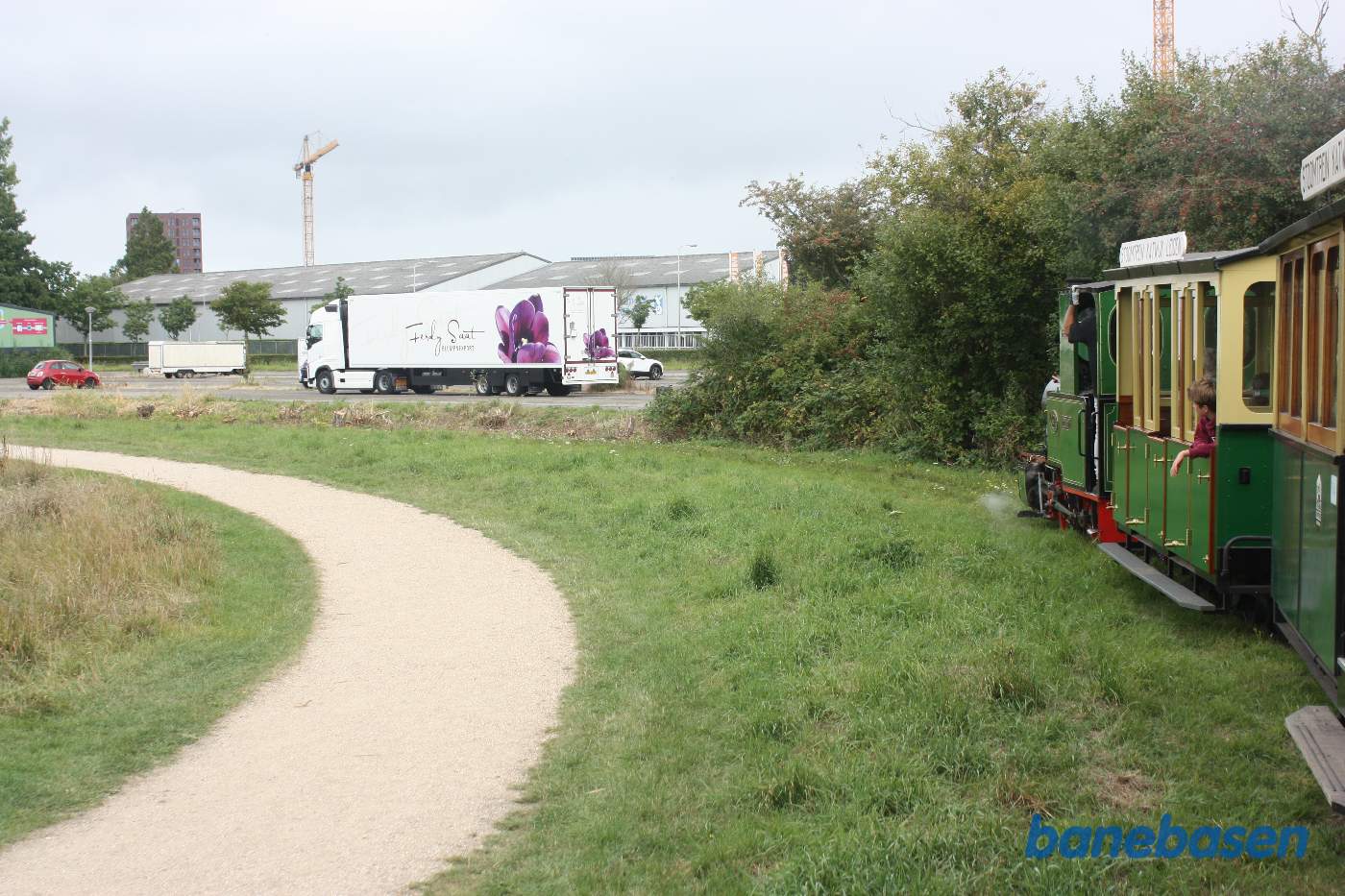 Toget kører i parken langs søen
