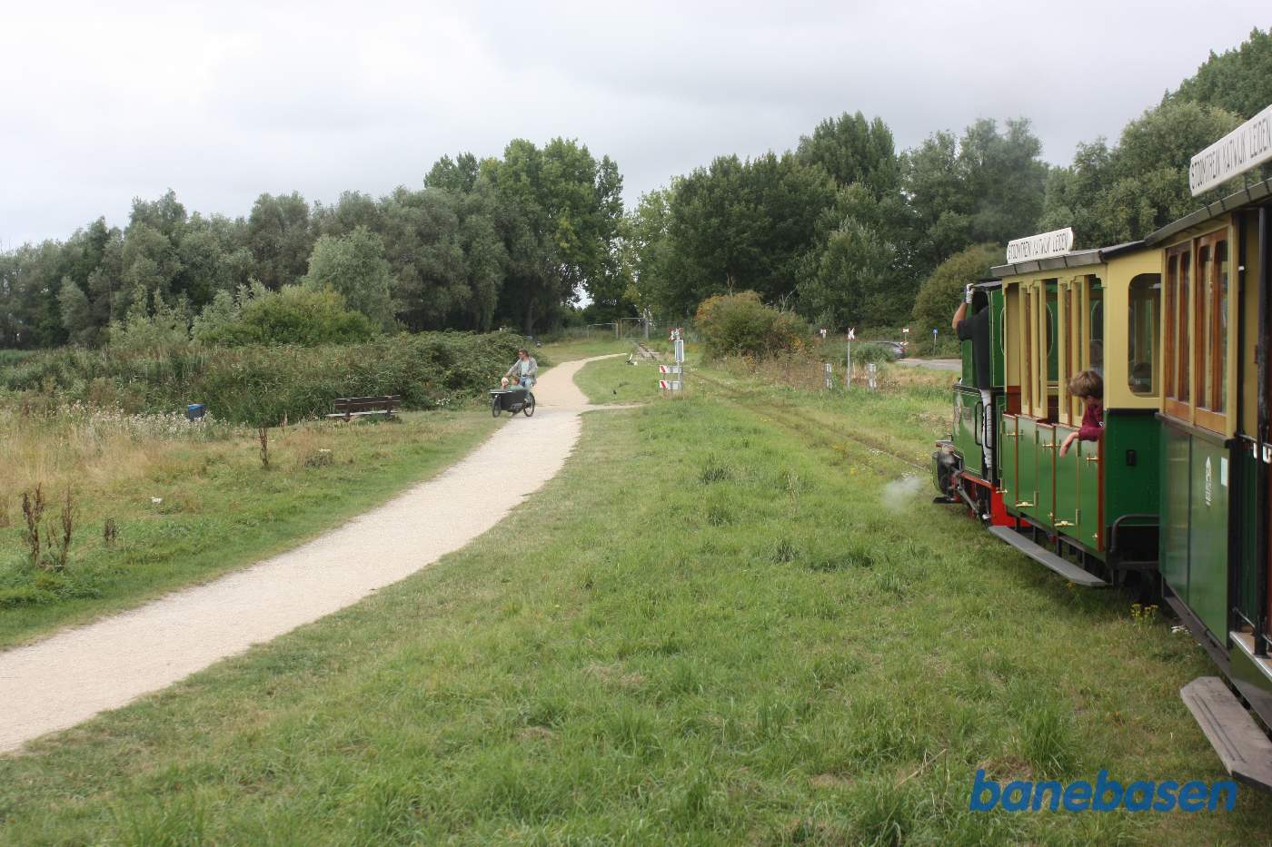 Toget kører i parken langs søen