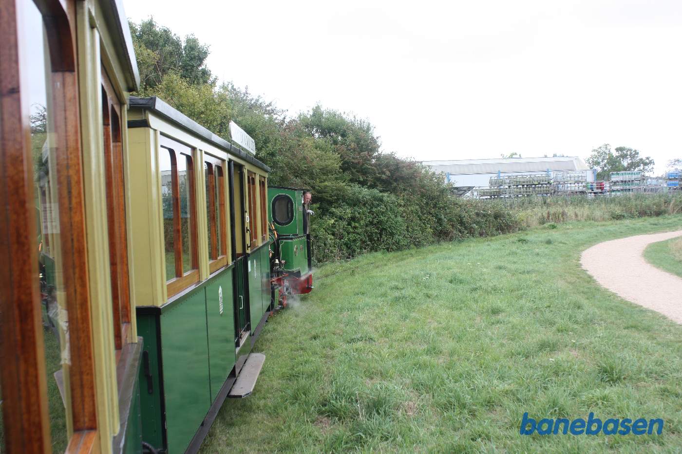 Toget kører i parken langs søen