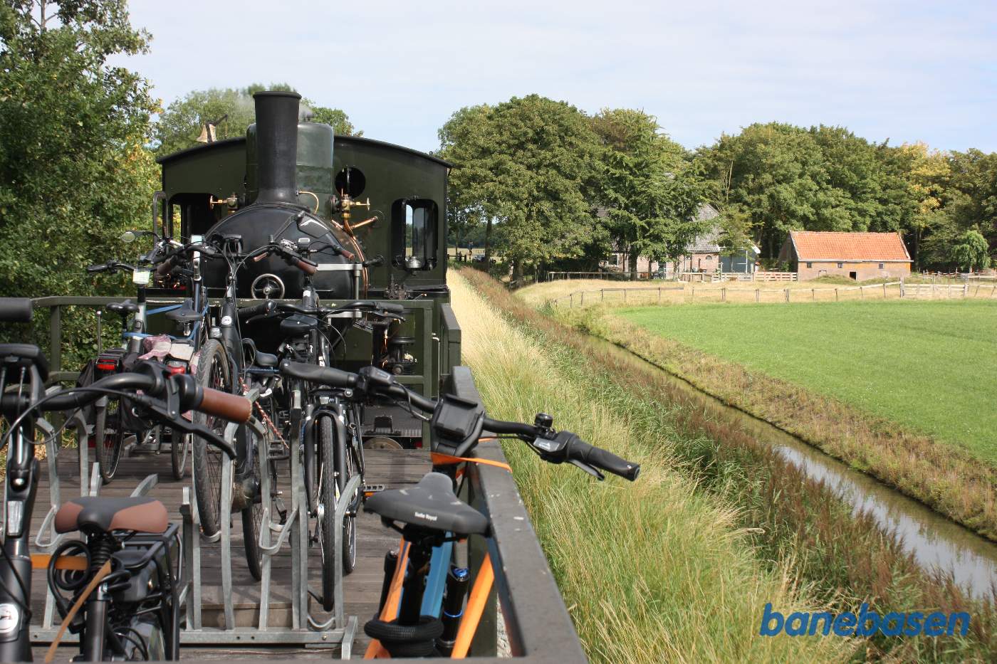 Banen går langs en bred grøft fyldt med vand. Næste station lige fremme