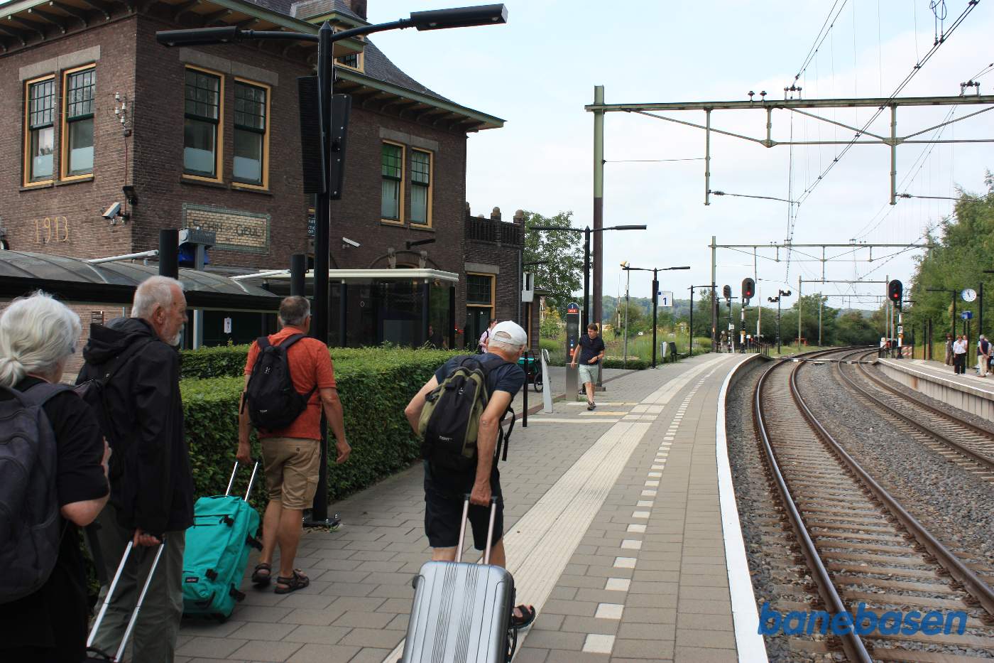 Stationsbygningen til venstre på perronen