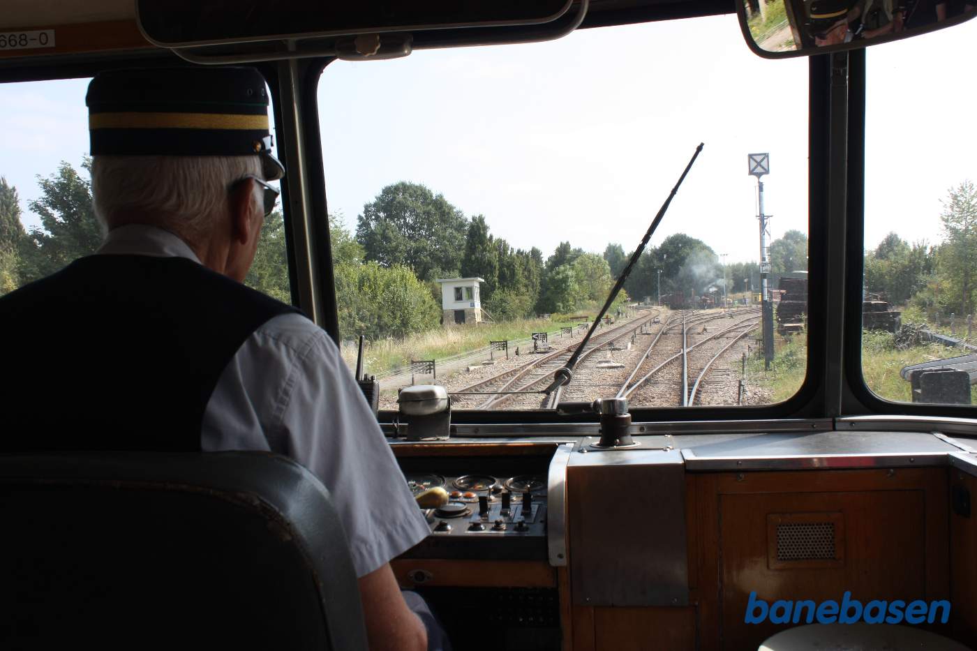 Føreren har startet skinnebussen, signalhuset på stationen ses i venstre side af frontvinduet