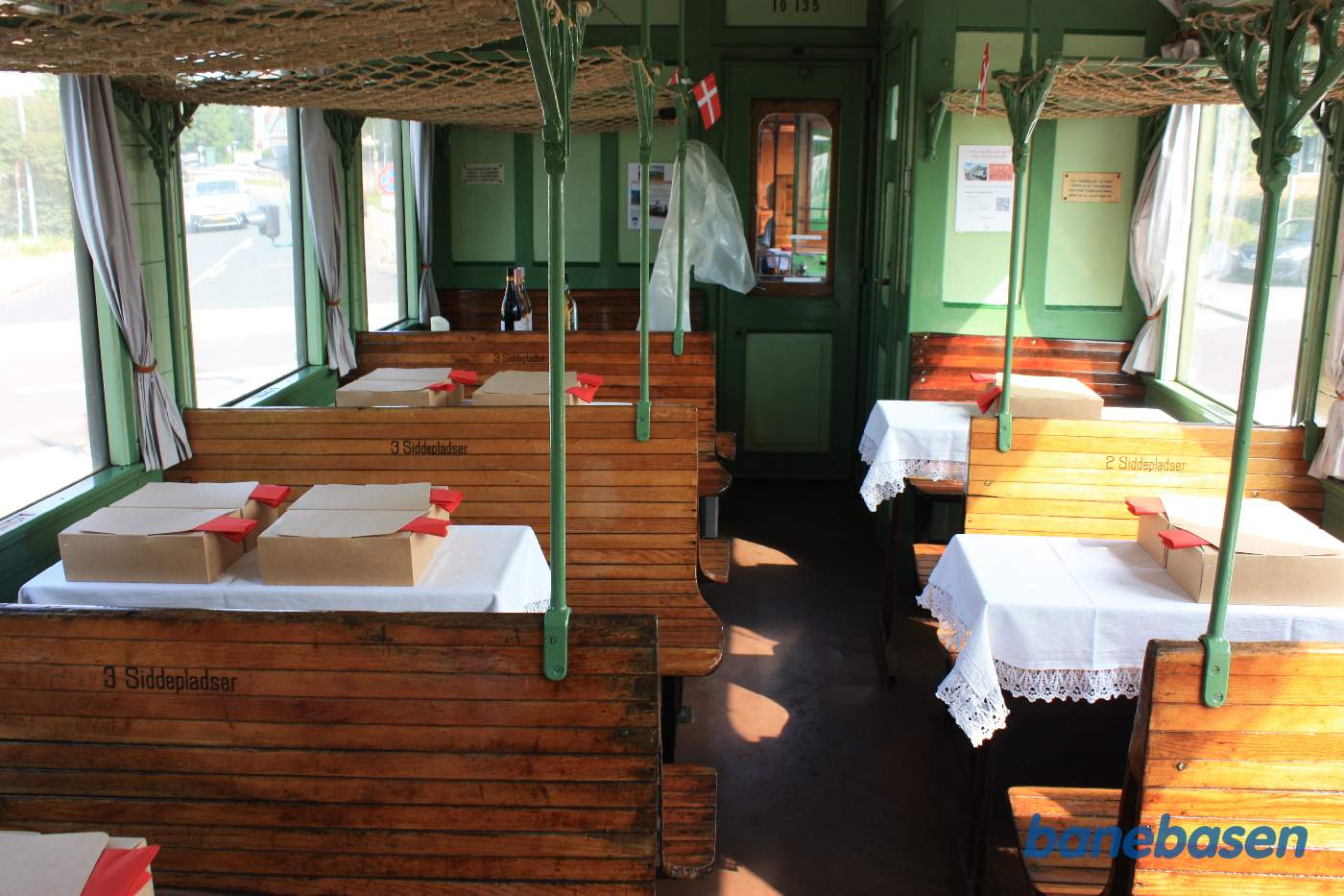 Der dækkes op på bordene til gæsterne. Papæskerne er færdig pakkede frokost anretninger, bordet med drikkevare ses for enden af vognen til venstre