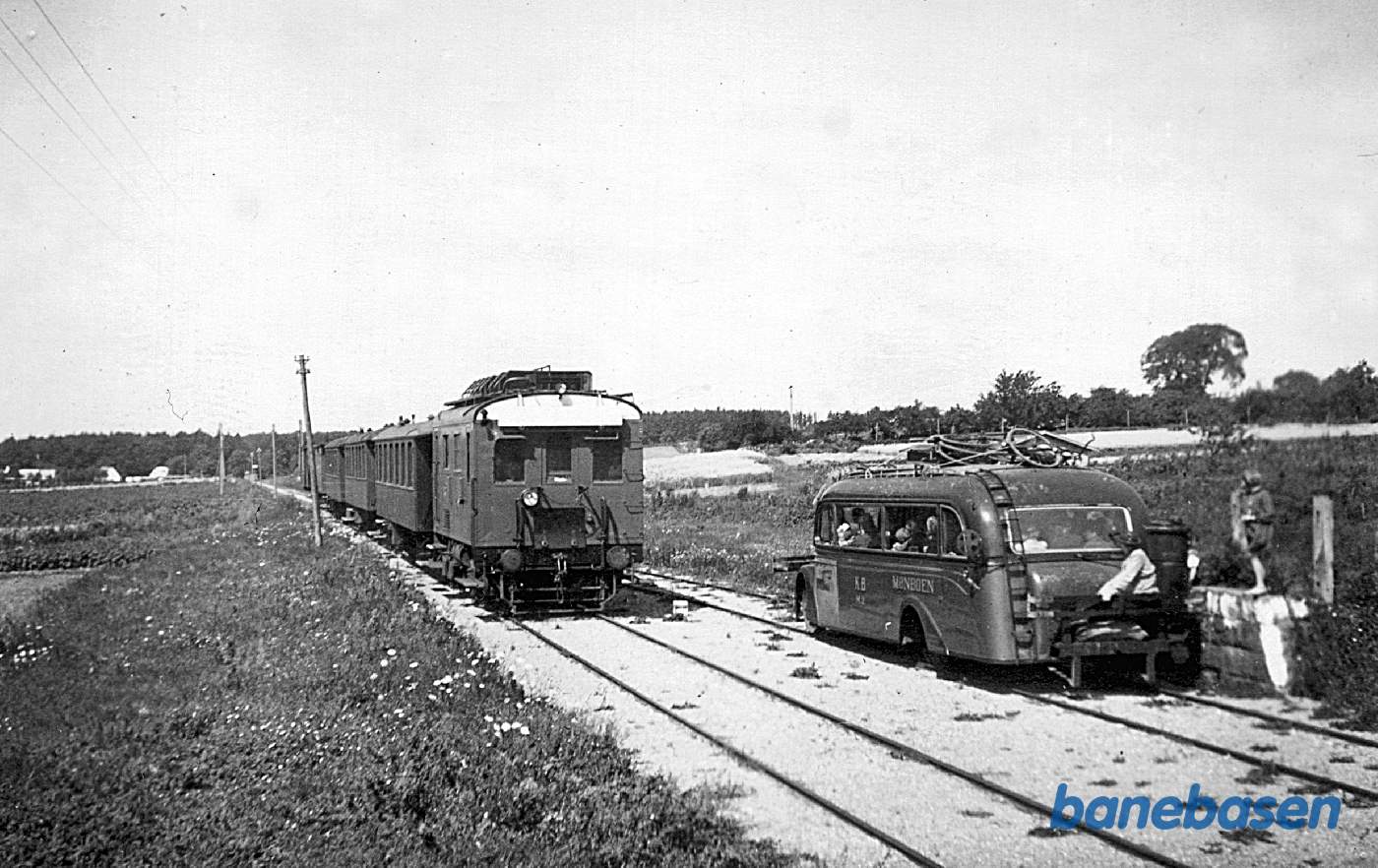 M 1 med tre toakslede DSB-personvogne krydser den endnu gengasdrevne og godt læssede skinnerutebil M 2 ("Mønboen")