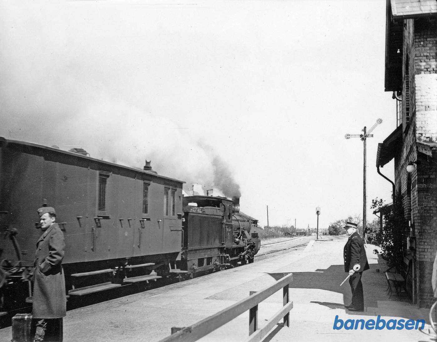 Stationsmesteren er klar til at give afgang for toget mod Nyborg