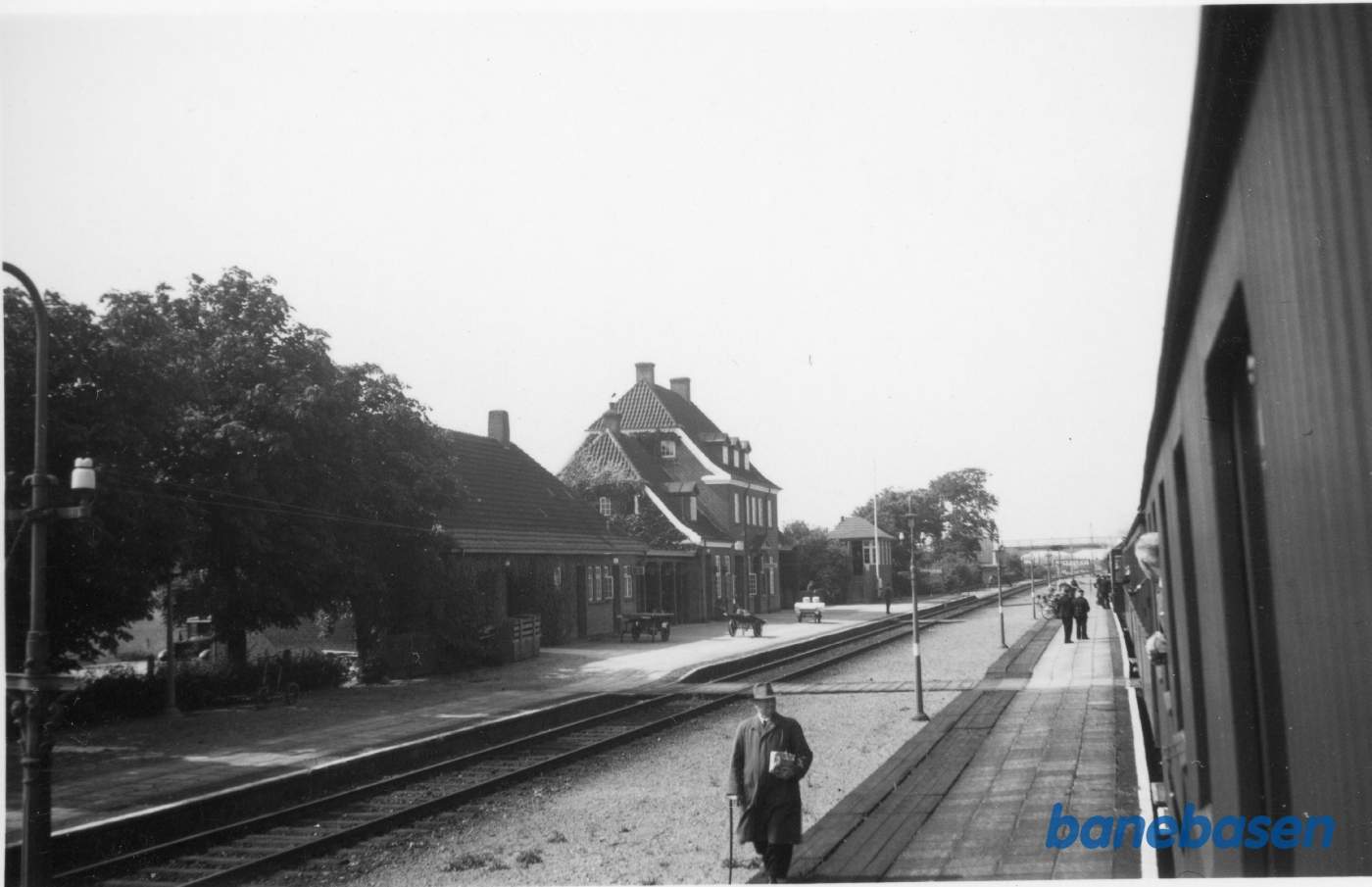 Varehus, stationsbygning og signalpost, vejbro i baggrunden